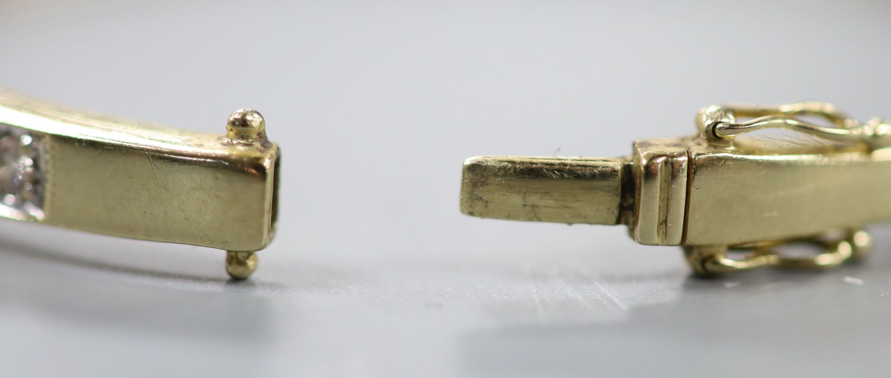A modern 585 yellow metal and diamond chip set hinged bangle, interior diameter 62mm